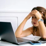Auto-entrepreneure du web stressée devant son ordinateur – erreurs à éviter quand on se lance en ligne